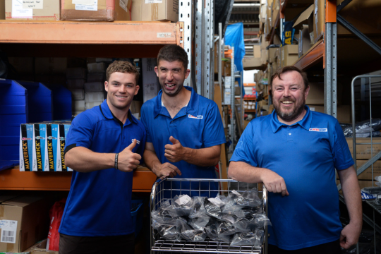 Rocky Bay customer Chris with his support worker and colleague, smiling at the camera.