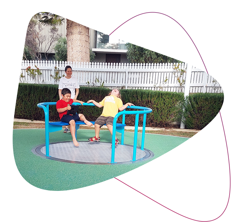 Rocky Bay customers Samuel and Matiu playing on the accessible roundabout at LLC